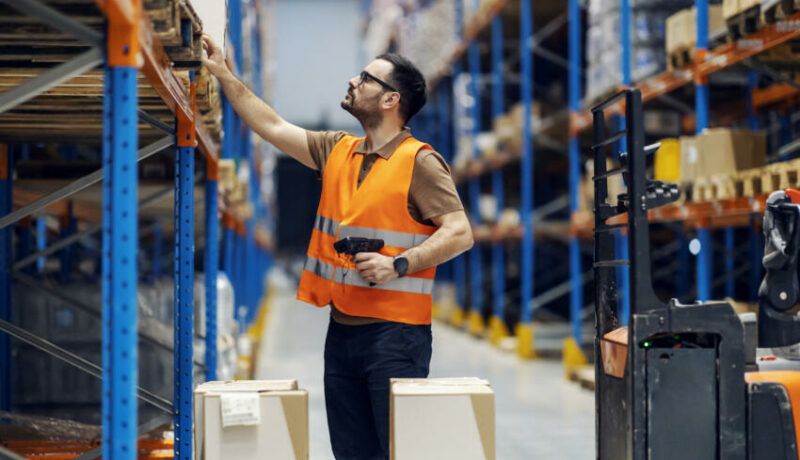 a worker in a manufacturer warehouse is able to work efficiently with the best manufacturing erp software at their fingertips